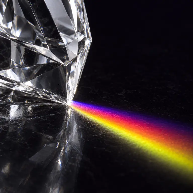 A spectral fringe of violet, magenta and citrine thrown across a dark surface